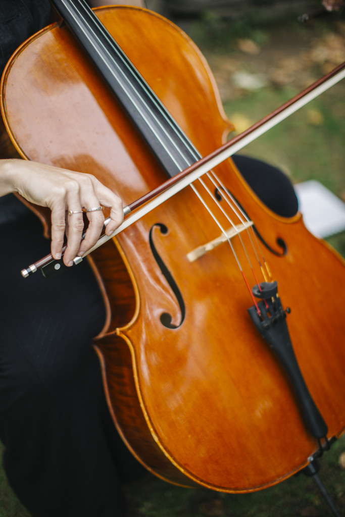 A close-up of a person playing a cello with a bow.