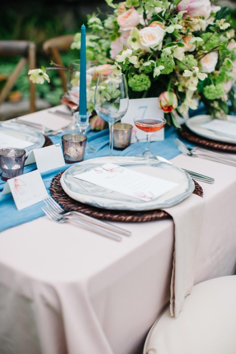 Elegant table setting with white plates and a blue candle.