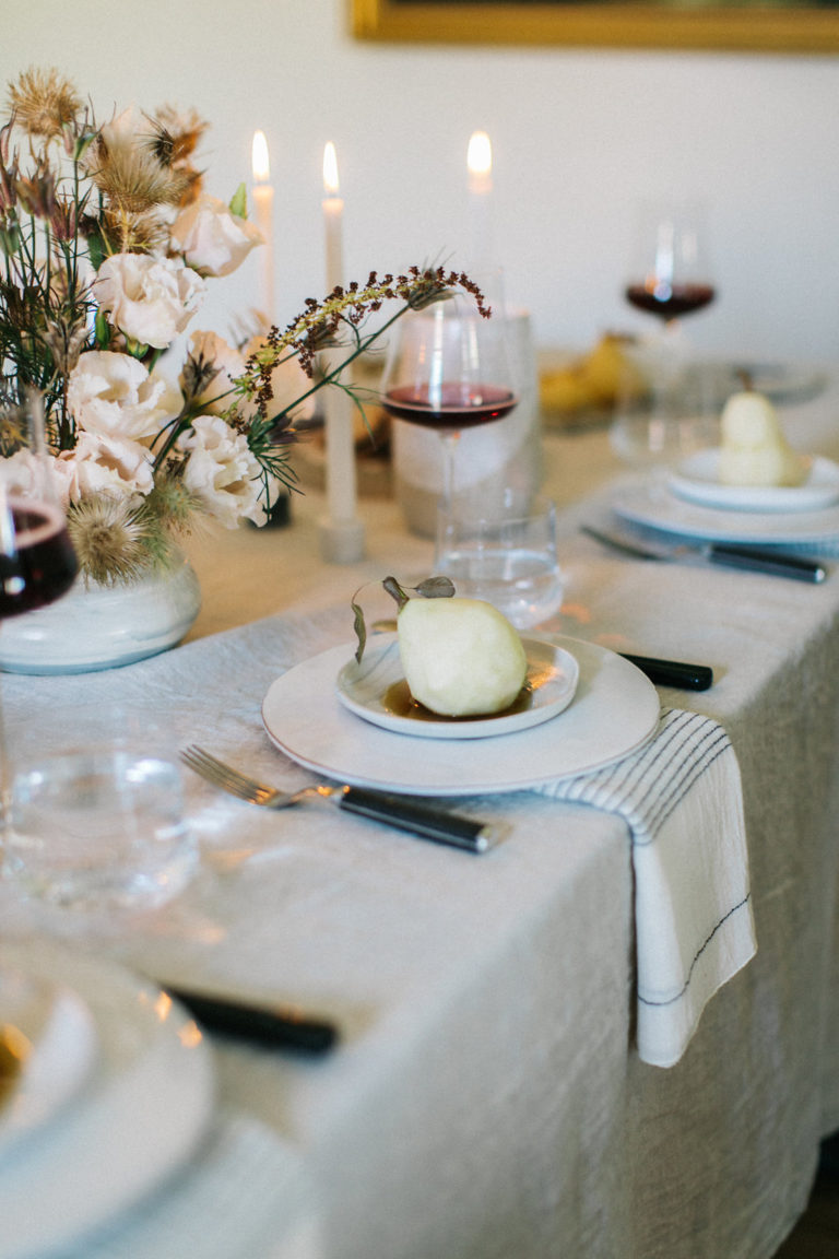 Elegant table setting with white plates and wine glasses.